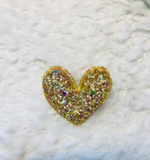 Découvrez notre broche coeur rembourré pailleté doré multicolore.