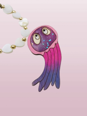 Laissez-vous envoûter par cette adorable broche méduse violet pailletée, un bijou unique qui allie douceur et éclat.