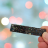 Ajoutez une touche de brillance à vos coiffures avec notre magnifique barrette en résine pailletée noire. Cet accessoire pour cheveux est à la fois chic et original