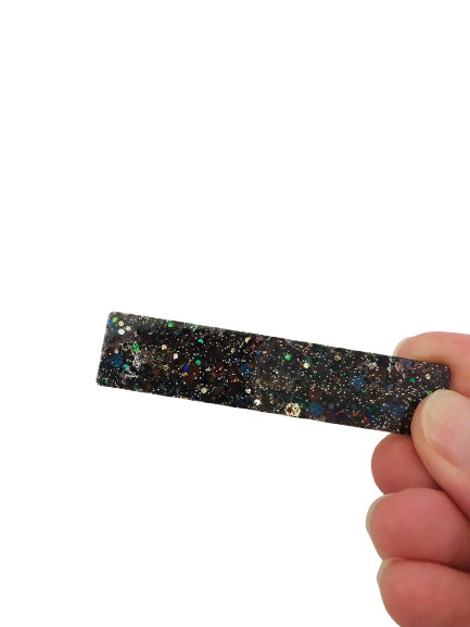 Ajoutez une touche de brillance à vos coiffures avec notre magnifique barrette en résine pailletée noire. Cet accessoire pour cheveux est à la fois chic et original