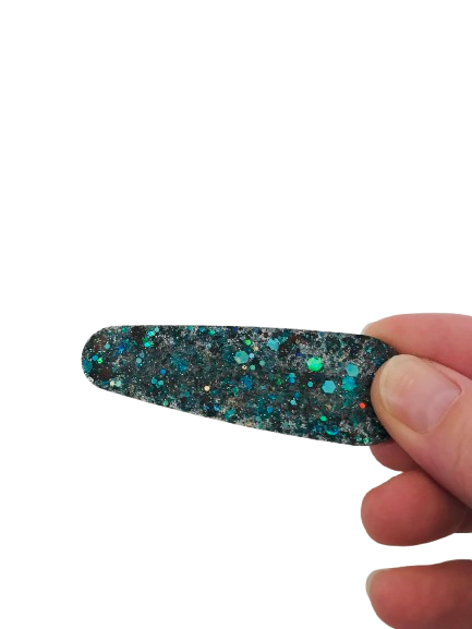 Ajoutez une touche d’élégance et de couleur à votre coiffure avec cette superbe barrette en résine verte pailletée. Conçue pour briller de mille feux.