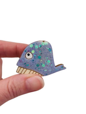 Plongez dans un océan de créativité avec notre broche baleine bleue pailletée, une pièce artisanale conçue avec amour et inspirée d’une histoire de famille.
