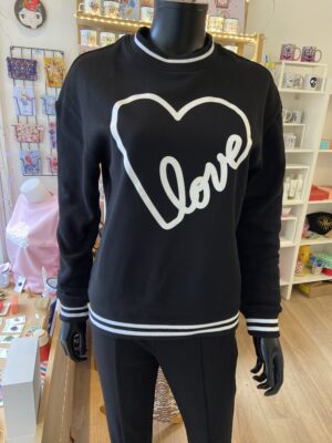 Ce sweat noir et blanc Love revisite le style streetwear avec une touche de délicatesse. Sur un fond noir profond, l’inscription “Love” se dessine en contour blanc, formant un grand cœur graphique. Ce contraste saisissant capture l’esprit urbain tout en apportant une note tendre et romantique.