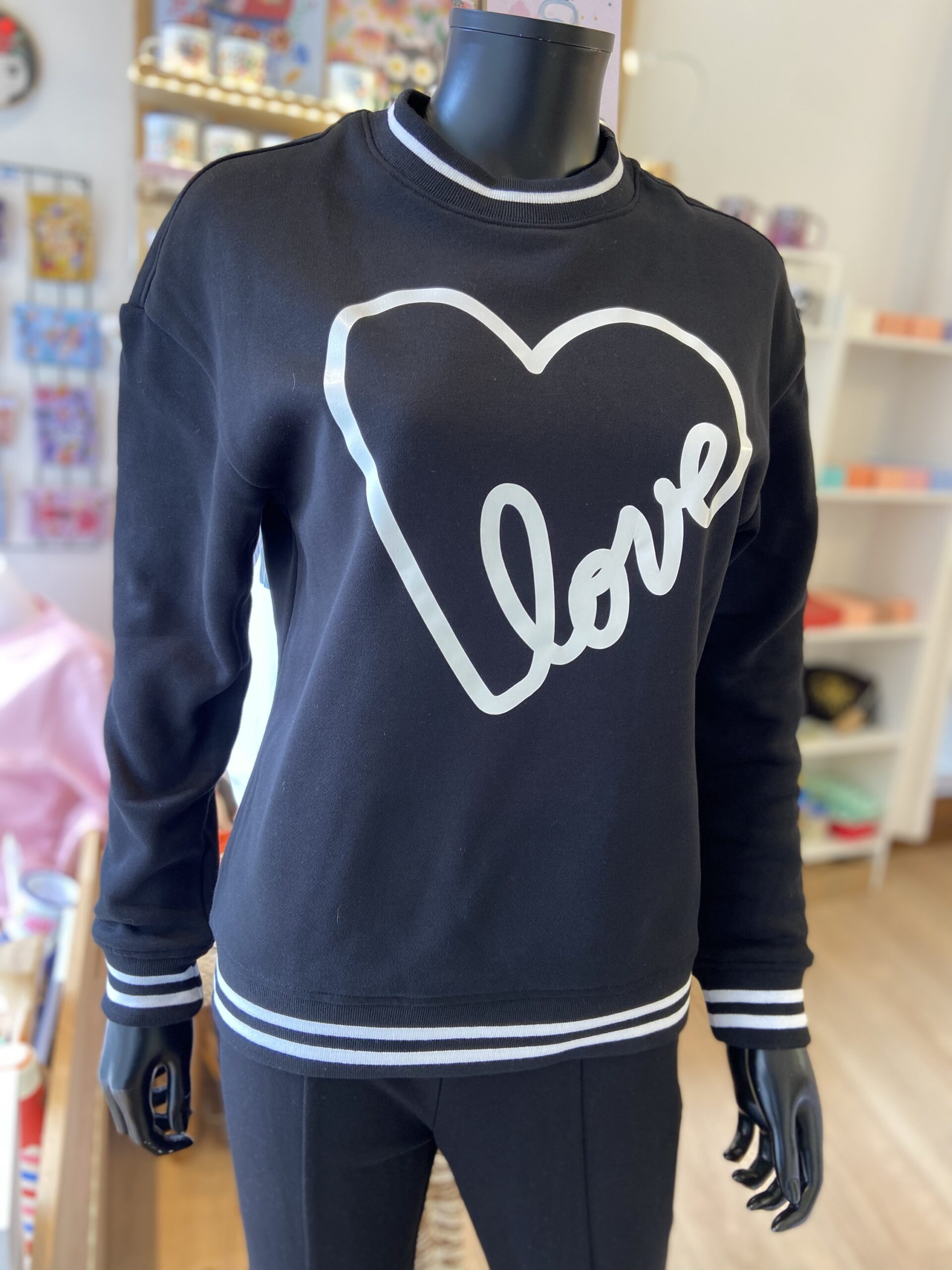 Ce sweat noir et blanc Love revisite le style streetwear avec une touche de délicatesse. Sur un fond noir profond, l’inscription “Love” se dessine en contour blanc, formant un grand cœur graphique. Ce contraste saisissant capture l’esprit urbain tout en apportant une note tendre et romantique.