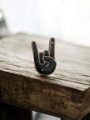 Affichez votre amour pour le rock et l’attitude badass avec cette broche "Hell Yeah" gris foncé pailletée. Entièrement fabriquée à la main dans notre atelier