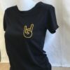 Découvrez le t-shirt Hell Yeah pailleté , une création unique réalisée artisanalement dans notre atelier situé entre Nantes et Clisson, le berceau du légendaire festival Hellfest. Ce t-shirt noir ou blanc arbore fièrement le motif emblématique des cornes du diable, symbole universel du rock et du métal, en version pailletée dorée pour un style résolument affirmé. Fabriqué à la main dans notre atelier local, chaque pièce est personnalisable : choisissez la couleur du motif selon vos envies pour un t-shirt qui vous ressemble vraiment.