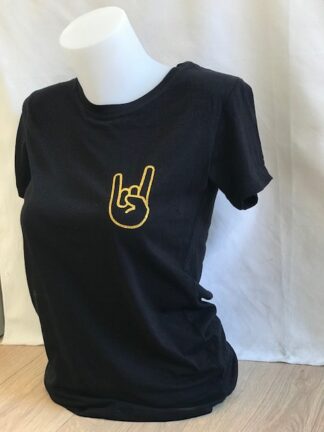 Découvrez le t-shirt Hell Yeah pailleté , une création unique réalisée artisanalement dans notre atelier situé entre Nantes et Clisson, le berceau du légendaire festival Hellfest. Ce t-shirt noir ou blanc arbore fièrement le motif emblématique des cornes du diable, symbole universel du rock et du métal, en version pailletée dorée pour un style résolument affirmé. Fabriqué à la main dans notre atelier local, chaque pièce est personnalisable : choisissez la couleur du motif selon vos envies pour un t-shirt qui vous ressemble vraiment.