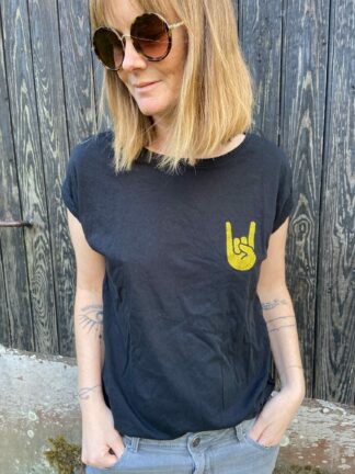 Laisse parler ton côté rock et glamour avec notre t-shirt noir Hell Yeah ! Avec son sigle pailleté doré rempli sur le cœur et son petit cœur doré discret dans la nuque, c’est bien plus qu’un simple T-shirt : c’est une déclaration de style. Conçu et personnalisé dans notre atelier entre Nantes et Clisson, il reflète l’ADN de la boutique : pièces originales, limitées et ultra-tendances.