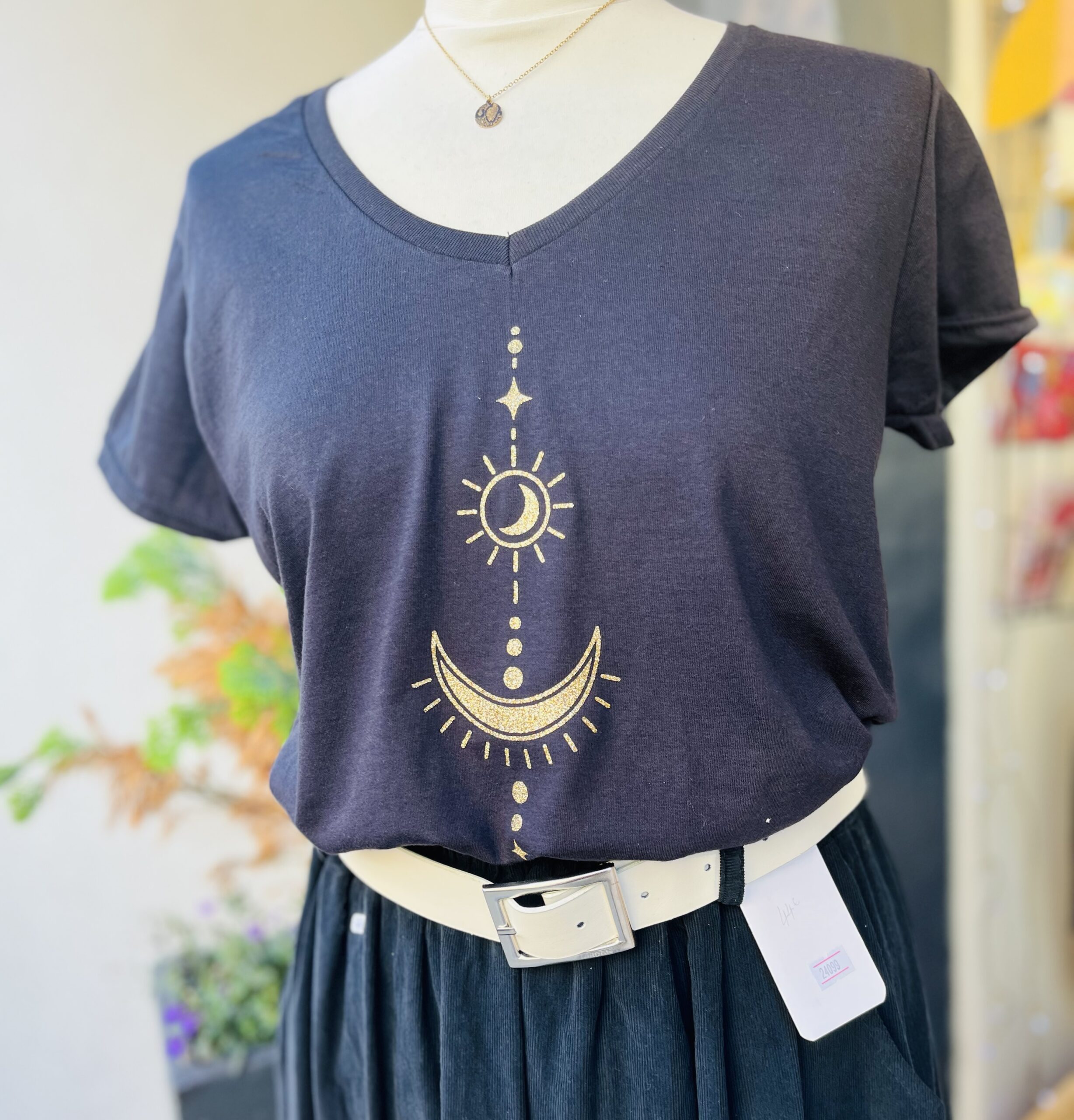 Notre t-shirt femme col V noir motif lune et soleil doré pailleté a été pensé pour celles qui aiment les univers célestes, la féérie et les détails qui brillent.