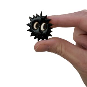 Broche kawaii petite boule de suie : broche en bois peint, résinée et pailletée. Elle a de grands yeux ronds et plein de petits piques : voici ta nouvelle petite boule de suie